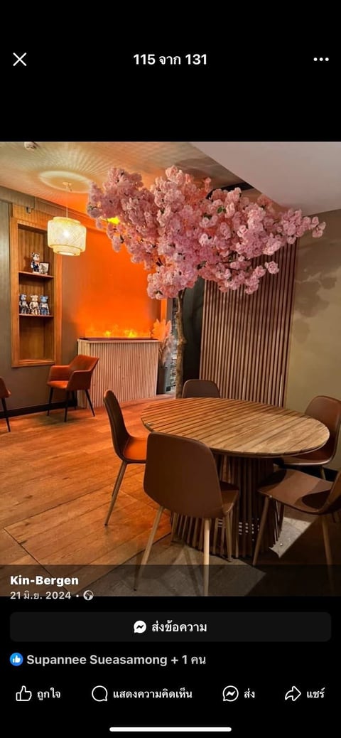 Modern dining room with oval wooden table, black chairs, vibrant orange wall