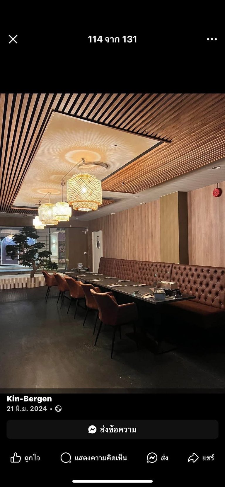 Modern restaurant dining area with wooden striped ceiling, pendant lights, burgundy seating