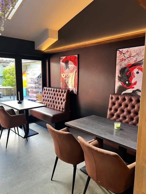 Modern cafe interior with brown leather booth seating, dining tables, warm accent lighting