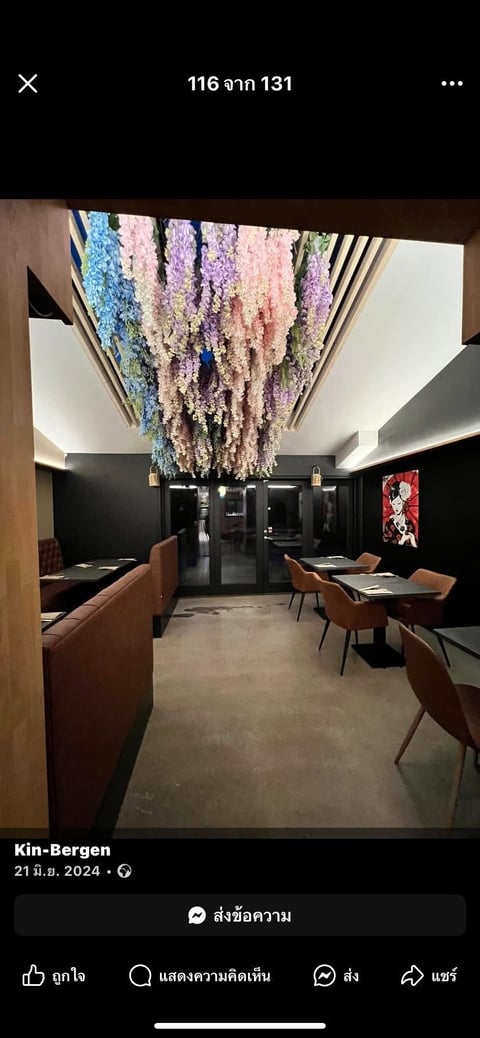 Modern restaurant interior with hanging floral installation in pastel colors above dining area