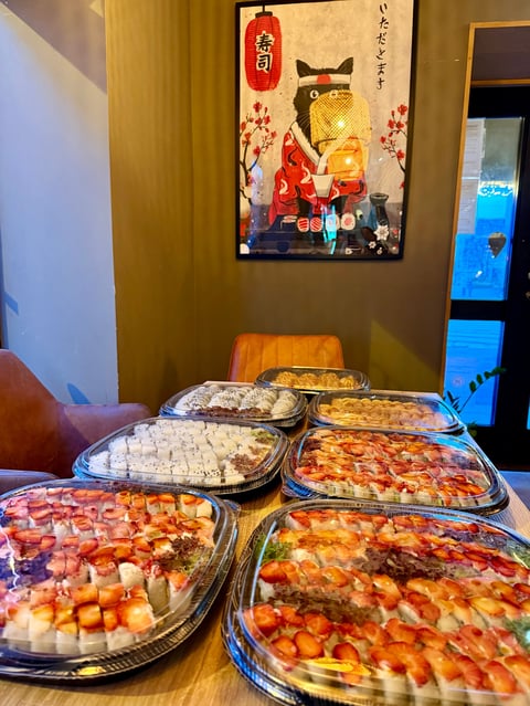Table display of multiple pizzas with Asian decor featuring golden cat artwork